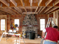 man working with trowel and mortar tiling a bathroom wall